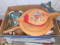 Overview of box showing bellows, platter, mugs, ceramic house, utensils, jar