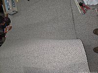 Beige carpet section folded back on floor