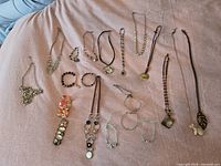All 18 costume jewelry pieces laid out on cloth