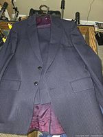 Full view of navy pinstripe jacket and glimpse of trousers