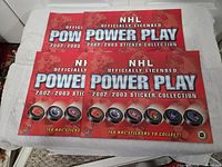 Four closed NHL Power Play sticker albums
