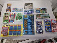 Group layout of various full-size scratch tickets on white cloth
