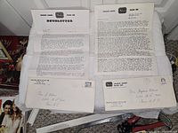 Both newsletters unfolded beside matching envelopes