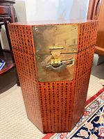 Front of octagonal box showing brass latch and Chinese script exterior