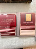 Open presentation binder showing red cards and mounted gold overlay stamp