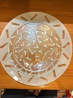 large and medium round frosted etched glass plates showing dots and dashes pattern
