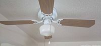 Overall view of ceiling-mounted 4-blade fan with light