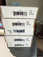 Stack of five sealed white United States Mint coin roll boxes showing barcodes and 2006 date