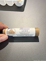 Paper-wrapped roll with U.S. Mint label showing 2009 Lincoln Cent 'Presidency' text