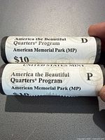 Two sealed United States Mint quarter rolls showing America the Beautiful Quarters Program, design American Memorial Park, mint marks P and D.