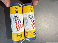 Two sealed United States Mint quarter rolls marked $10, Puerto Rico, letters P and D visible