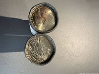 Two sealed coin rolls showing obverse and reverse quarter ends
