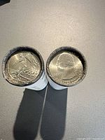 Two rolls standing upright showing obverse and reverse end coins