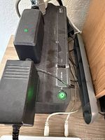 Close-up of APC UPS showing power button lit, connected cables, surface dust