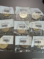 Eight individually wrapped Eisenhower dollar coins arranged on flat surface