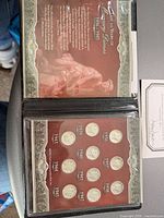 Display wallet open showing historical insert and ten Mercury dimes labeled by year