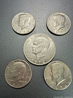 Group shot of all five coins showing denominations and dates