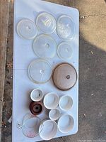 Full lot showing all glass lids, porcelain bowls, Pyrex cup and wood stand
