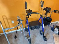Front view of blue rollator and silver folding walker