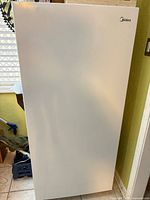 Front exterior view of white Midea upright freezer