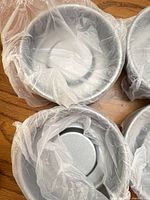 Four mini round cake pans in plastic wrap