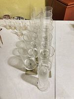 Row of tall clear cylindrical tumblers plus one inverted piece on table