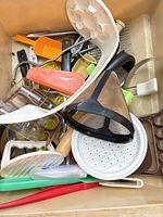 Bin containing assorted kitchen utensils and gadgets