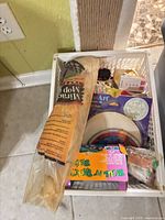 Top view of plastic basket showing mop head package, GlassArt kit, and other items