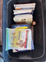 Top view of assorted books, magazines and paper items in plastic tote