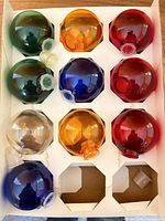 Nine assorted plastic globe bulb covers in tray