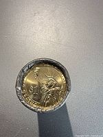 End view of roll showing Statue of Liberty reverse dollar coin