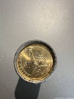 End of roll showing Statue of Liberty reverse of Presidential $1 coin