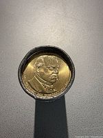 End view of roll showing Grover Cleveland $1 coin