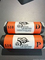 Two sealed US Mint State Quarters rolls showing P and D wrappers