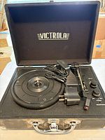 Open Victrola suitcase turntable with AC adapter inside