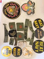 All items laid out: patches, buttons, name tapes, rank insignia, Zippo lighter