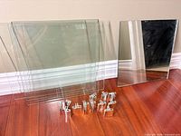 Group of clear glass panels, single mirror panel, and shelf clips