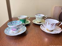 Four floral teacup and saucer sets on tabletop