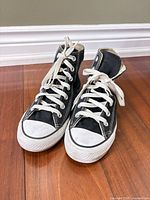 Front view of both black Converse high-tops showing uppers, laces, toe caps
