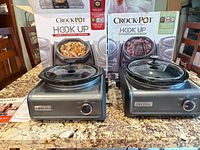 Both Crock-Pot Hook Up units with boxes, lids, manual visible