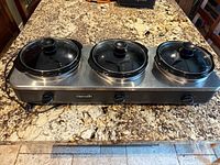 Full view of Crock-Pot triple slow cooker showing three pots and control knobs