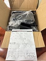 Open box showing bagged rack components and instruction sheet