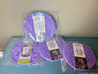 Four packaged purple snuffle mats on table