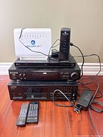 Stack of five electronic units with two remotes and power cords