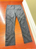Front view full length of black Lululemon leggings showing seam and mesh detail