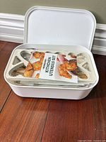 Storage box opened showing contents and instruction card