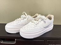 Side view of both white Nike platform sneakers