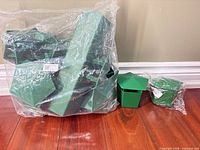 Bag containing multiple green plastic snail traps