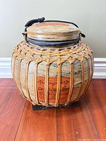 Full view of jar showing rattan cage, body color, script panel, lid and handle