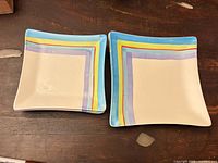Two square plates showing multicolor striped design